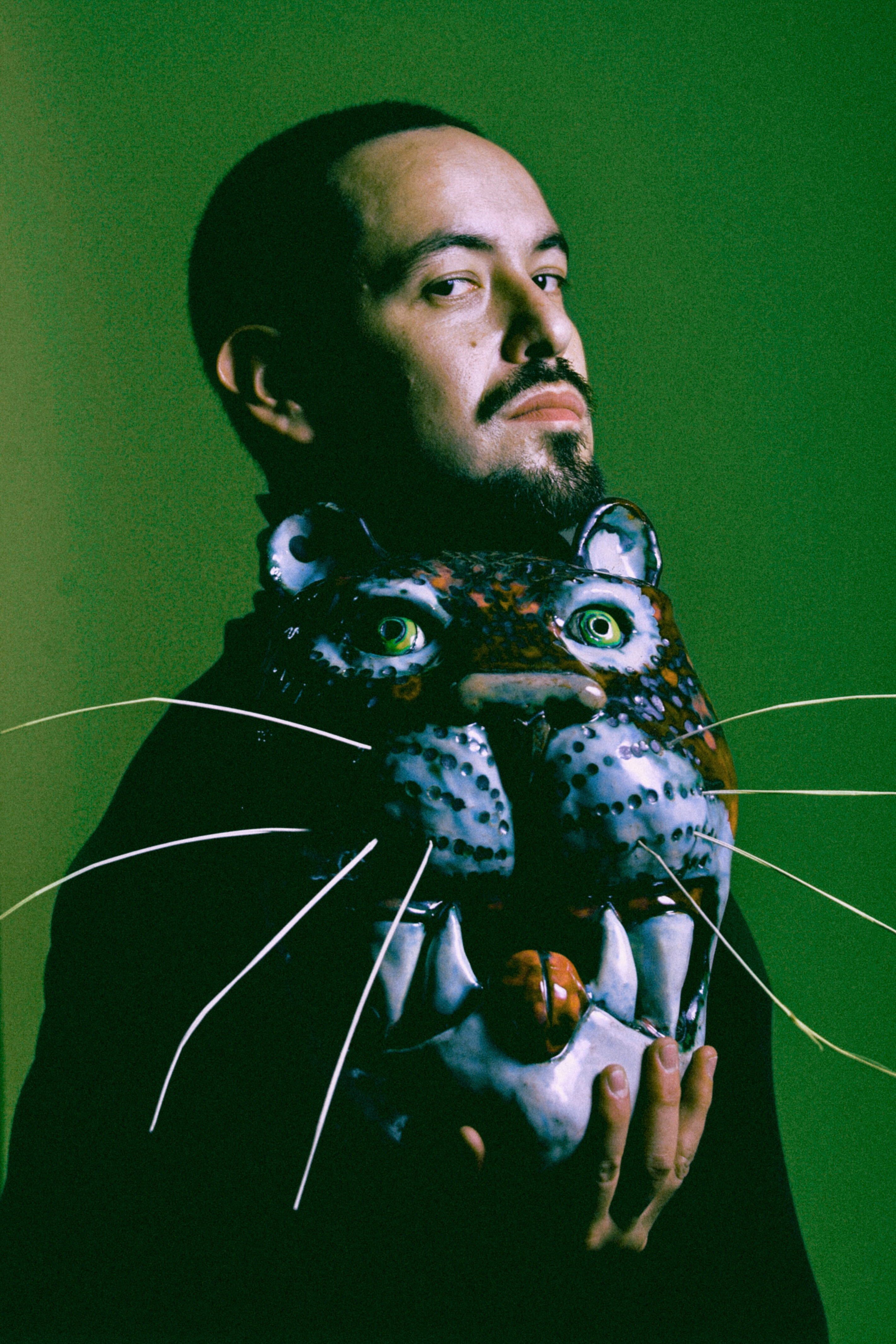 Portrait of José Cobos holding a ceramic jaguar mask